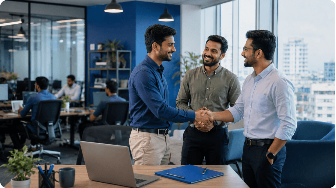 Two colleagues shaking hands as a third looks on in a RefCred office